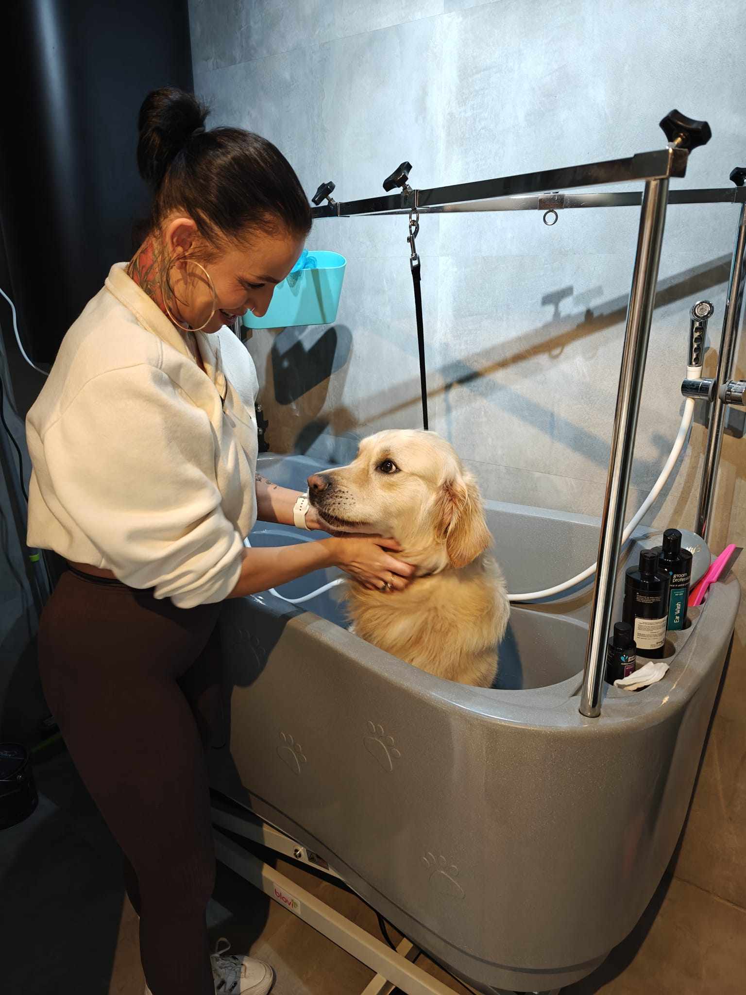 Gabriela wast een goudkleurige hond in de badkuip van de salon